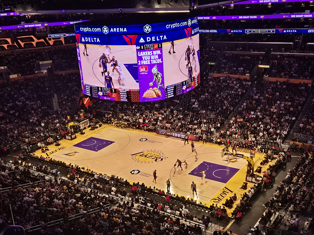 A dynamic view inside the packed Crypto.com Arena during a Los Angeles Lakers basketball game, capturing the city’s energetic sports culture.