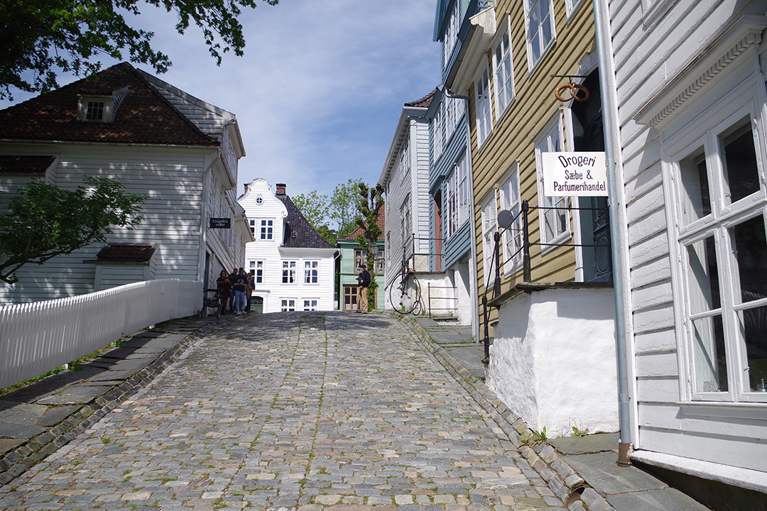 Walking among the wooden houses of Gamle Bergen, showcasing life in past centuries.
