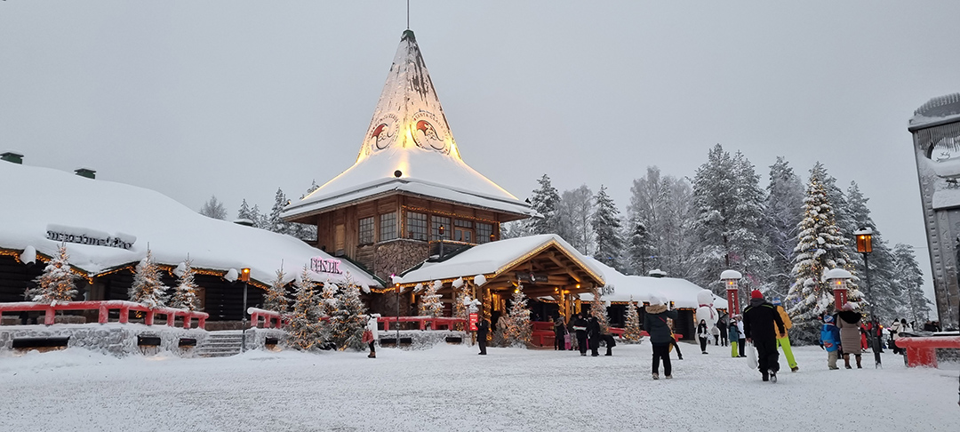 Santa Claus Village in Rovaniemi, Lapland, surrounded by snow and festive lights, offering visitors a fairytale Christmas atmosphere in northern Finland.