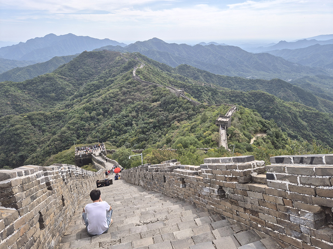 The Great Wall of China stretching across green mountain ridges, one of the greatest architectural achievements in human history and a symbol of China’s past.