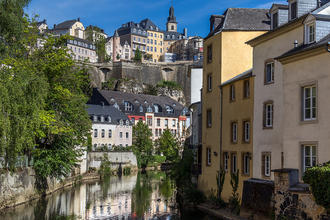 View of Luxembourg City old town with historic architecture, greenery and well-maintained urban landscape.
