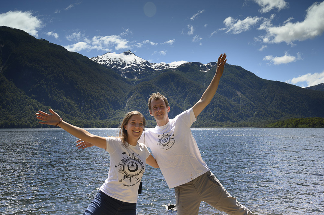Travel journalists standing by a mountain lake during their journey, exploring nature and collecting stories and experiences for travel articles and reports.