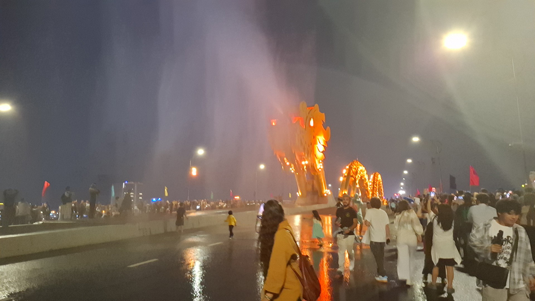 Dragon Bridge in Da Nang Vietnam at night, illuminated bridge with a crowd gathering during the evening fire and water show.