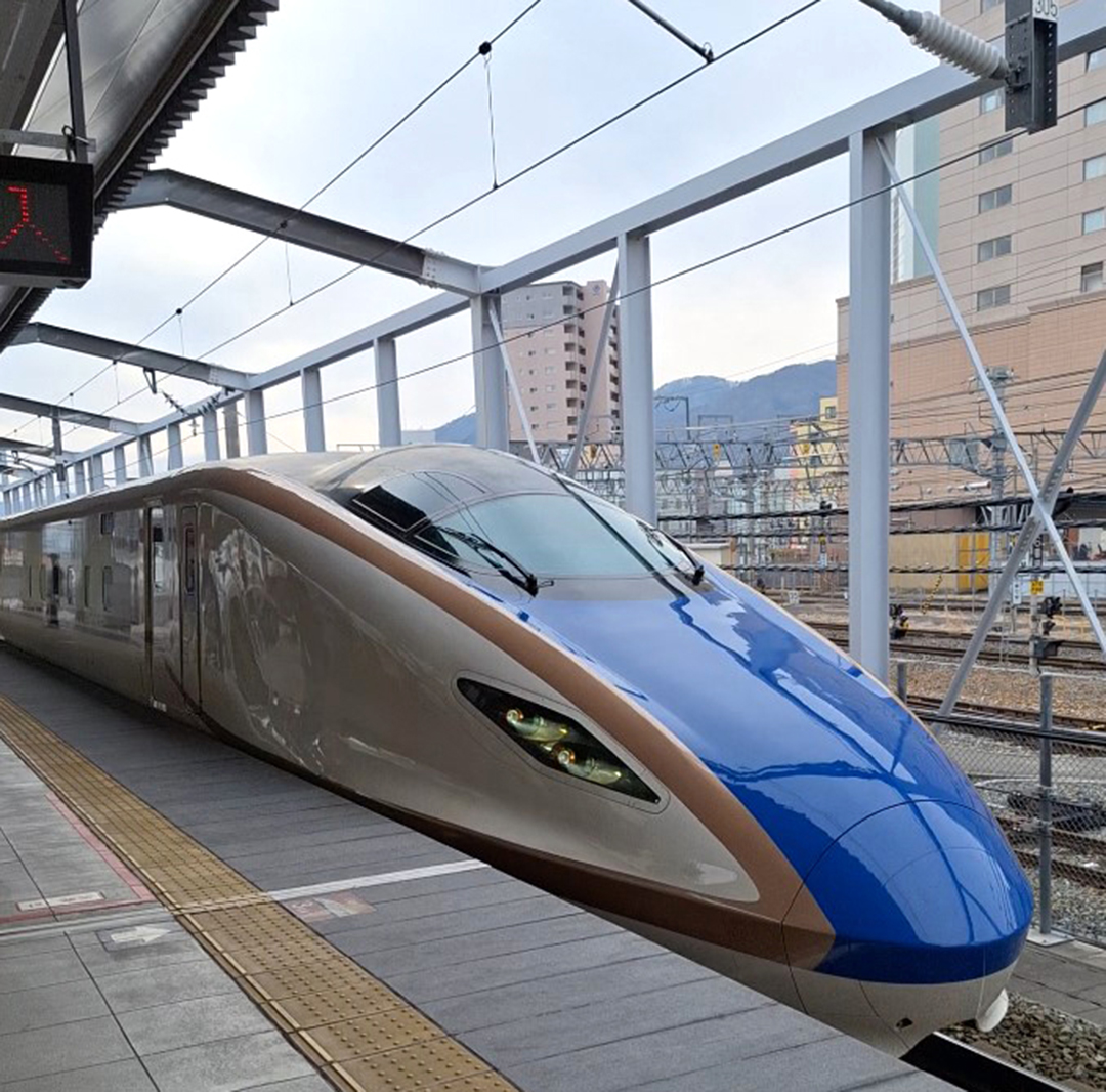 Modri hitri vlak Shinkansen na železniški postaji na Japonskem med potovanjem proti Naganu