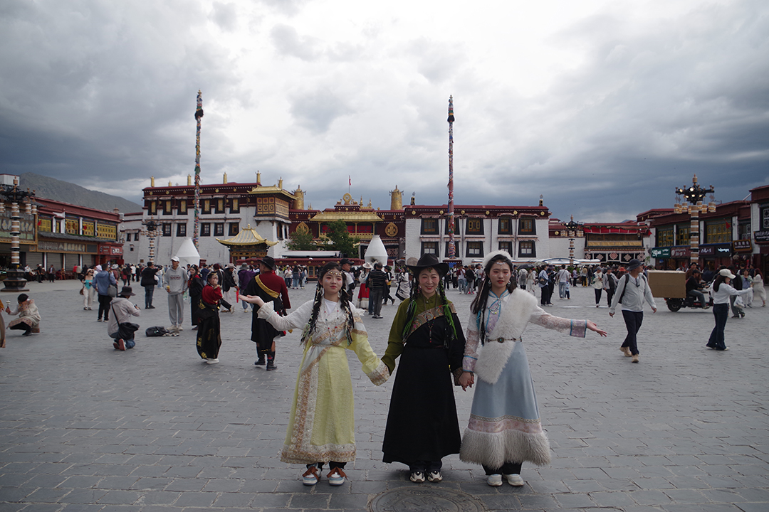 Obiskovalke v tradicionalnih tibetanskih oblačilih na trgu Barkhor pred templjem Jokhang v starem delu Lhase.