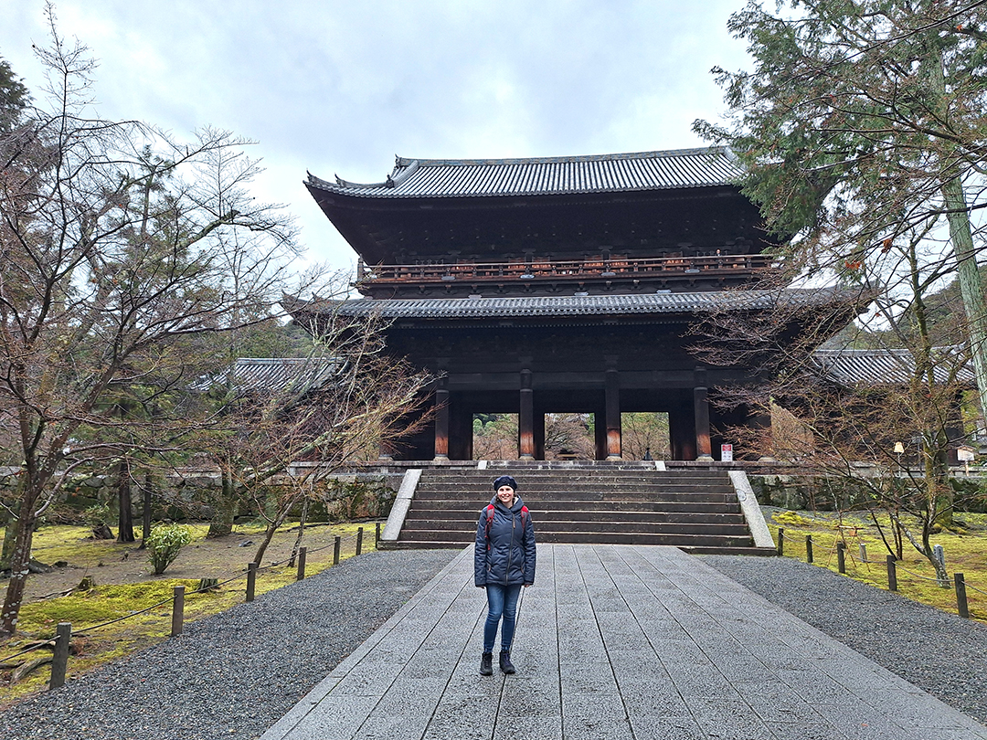 Obiskovalka pred mogočnimi tradicionalnimi vrati templja Nanzen-ji v Kyotu, enega najbolj znanih zenovskih templjev na Japonskem.